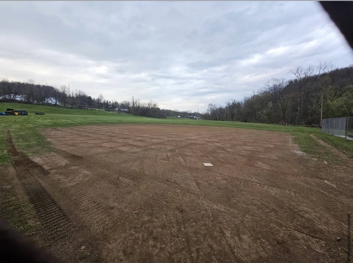 Skid steer working on outfield grading