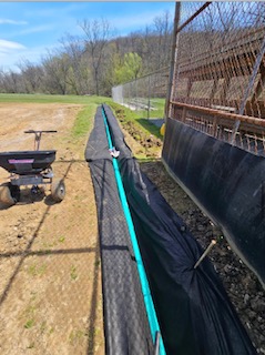 New drainage line installed along fence line