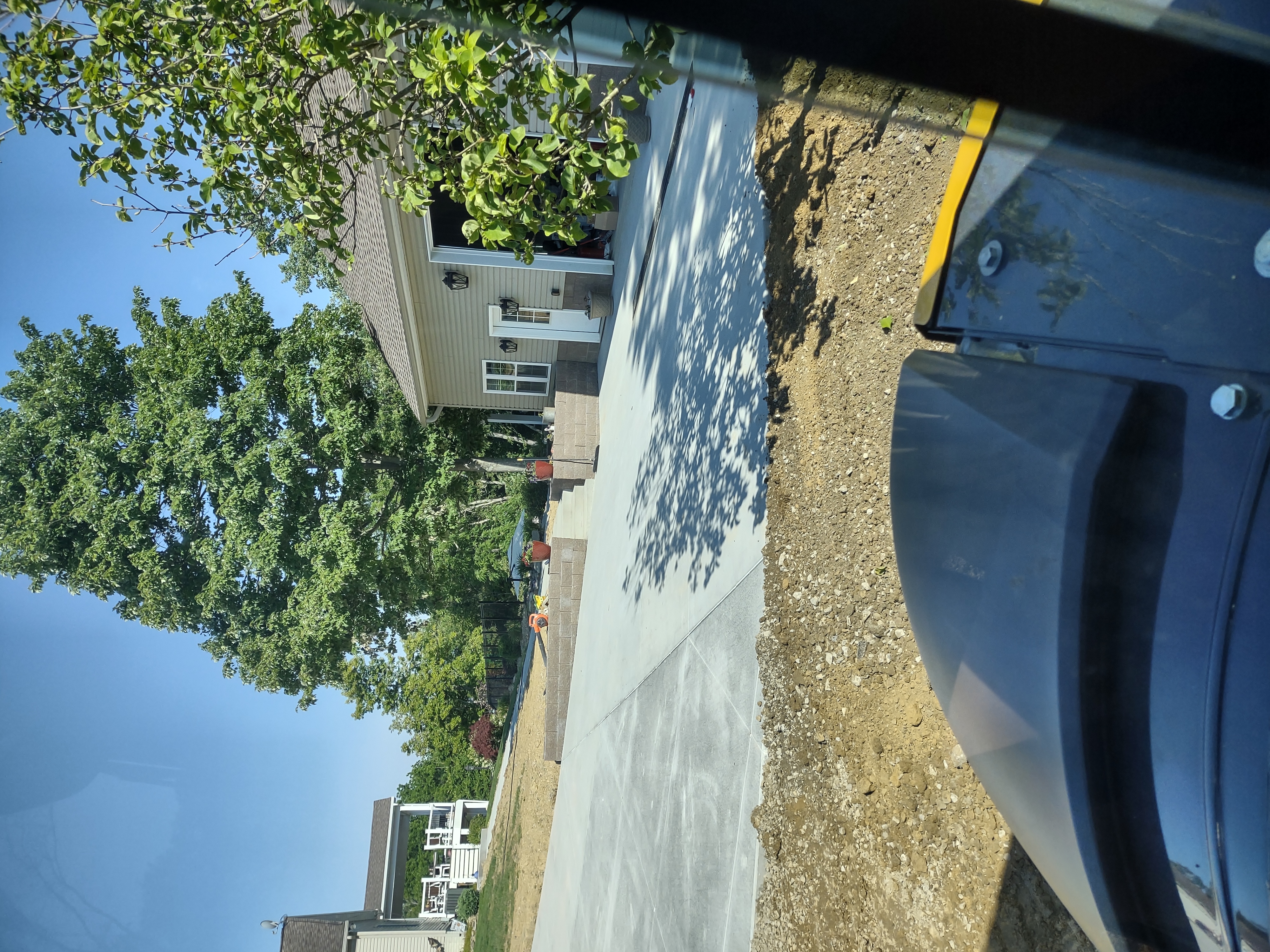 Wide driveway with retaining wall and steps from equipment cab