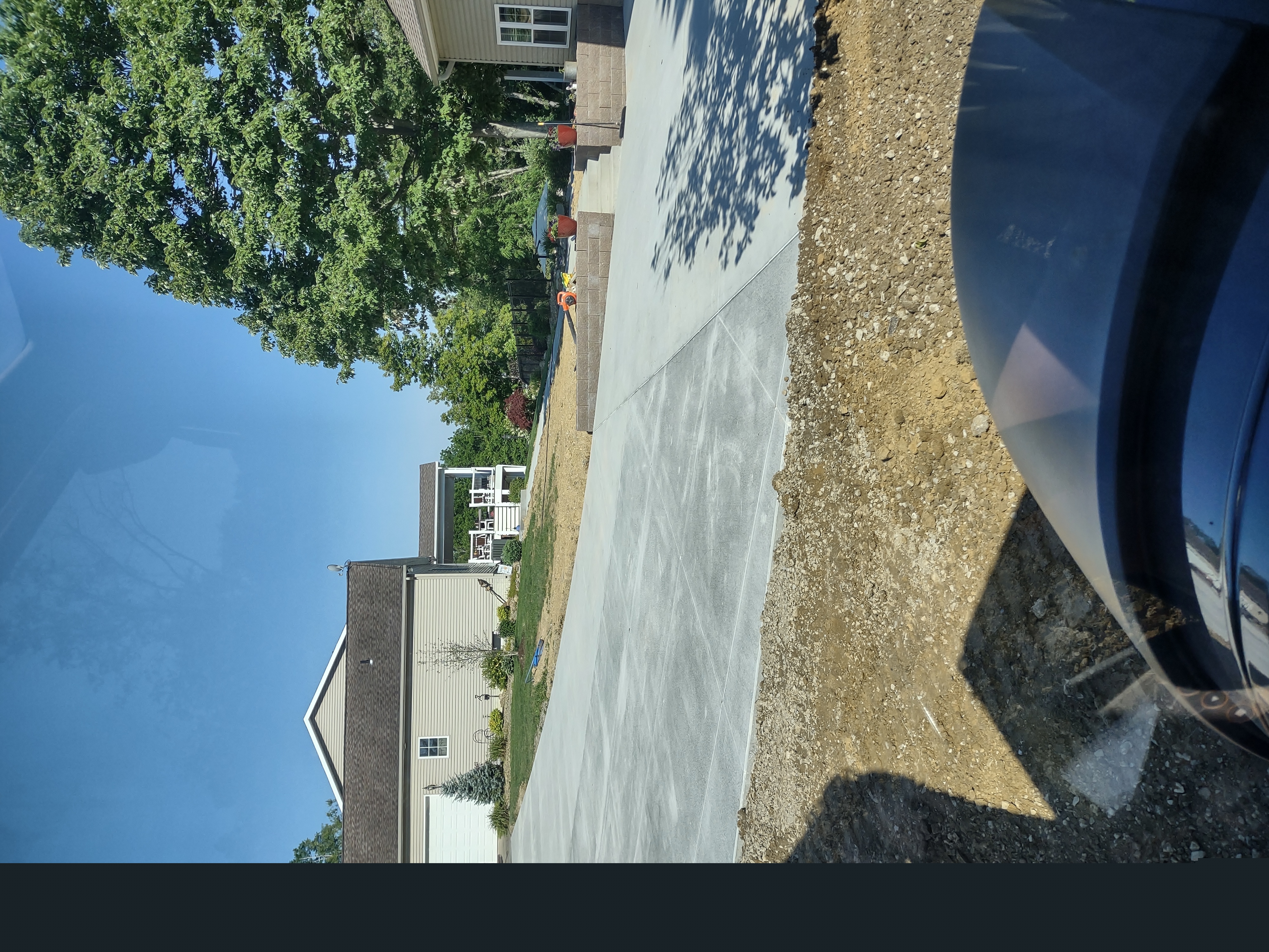 Wide angle showing full driveway and retaining wall area