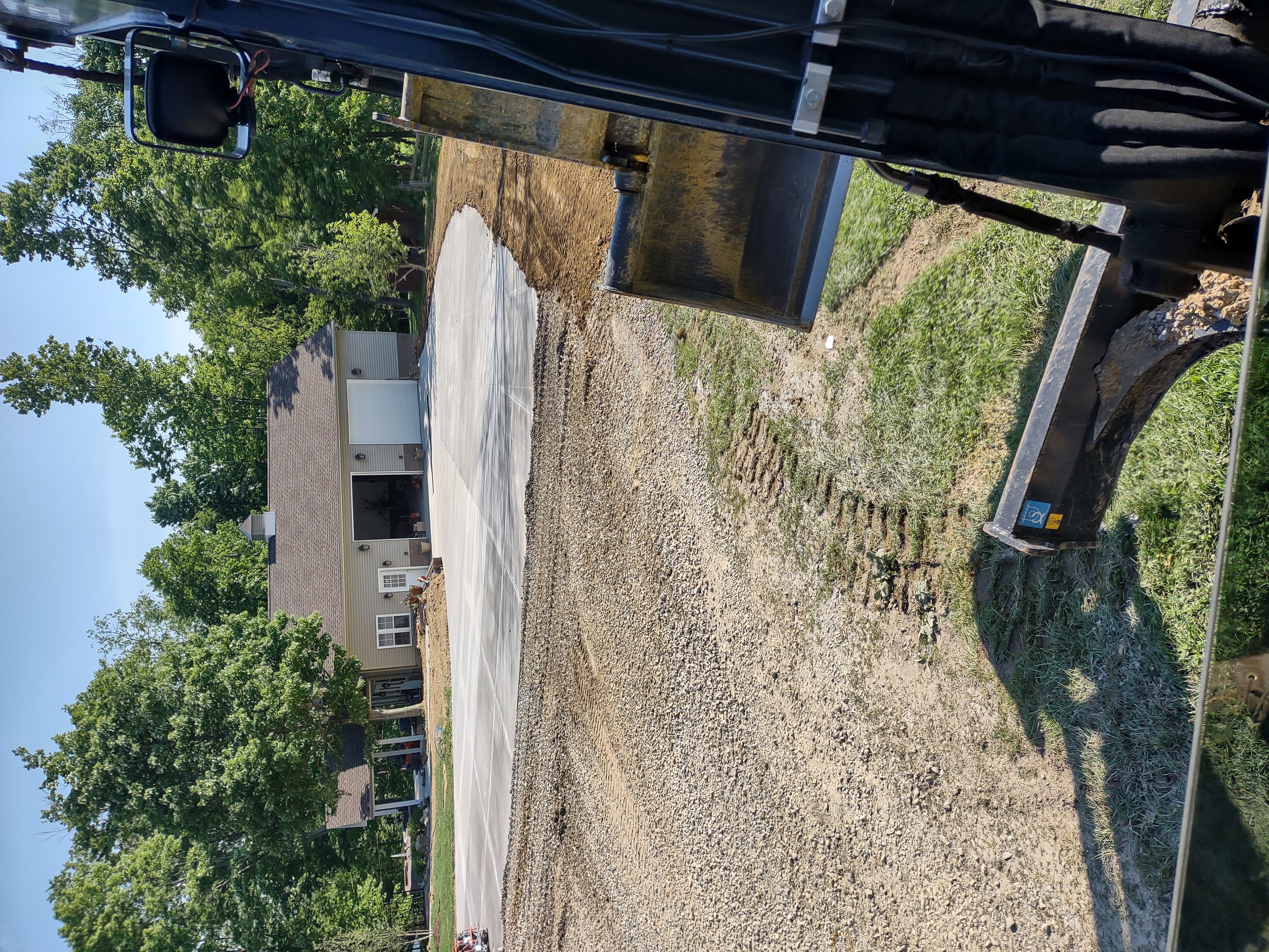 Excavator view of completed driveway with gravel parking area