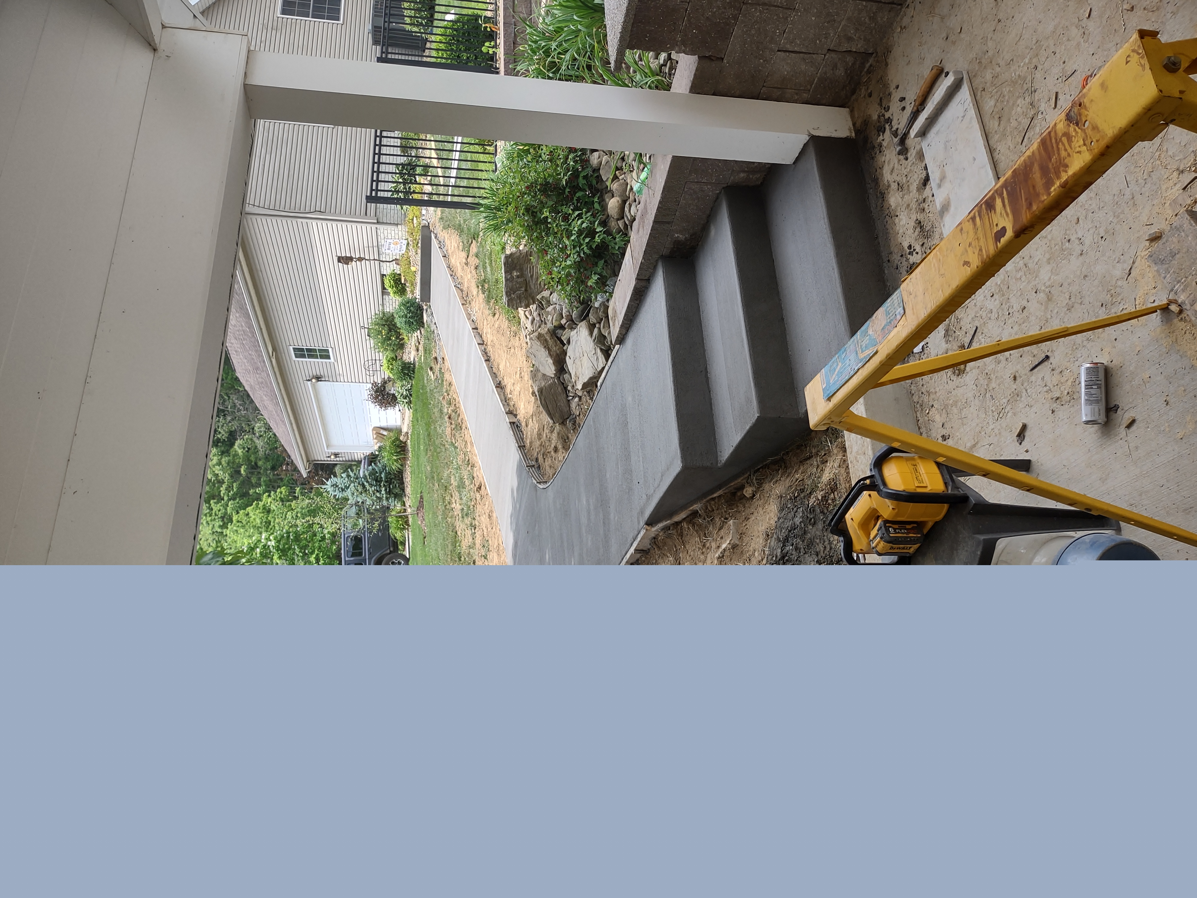 Freshly poured concrete entry steps with curved sidewalk