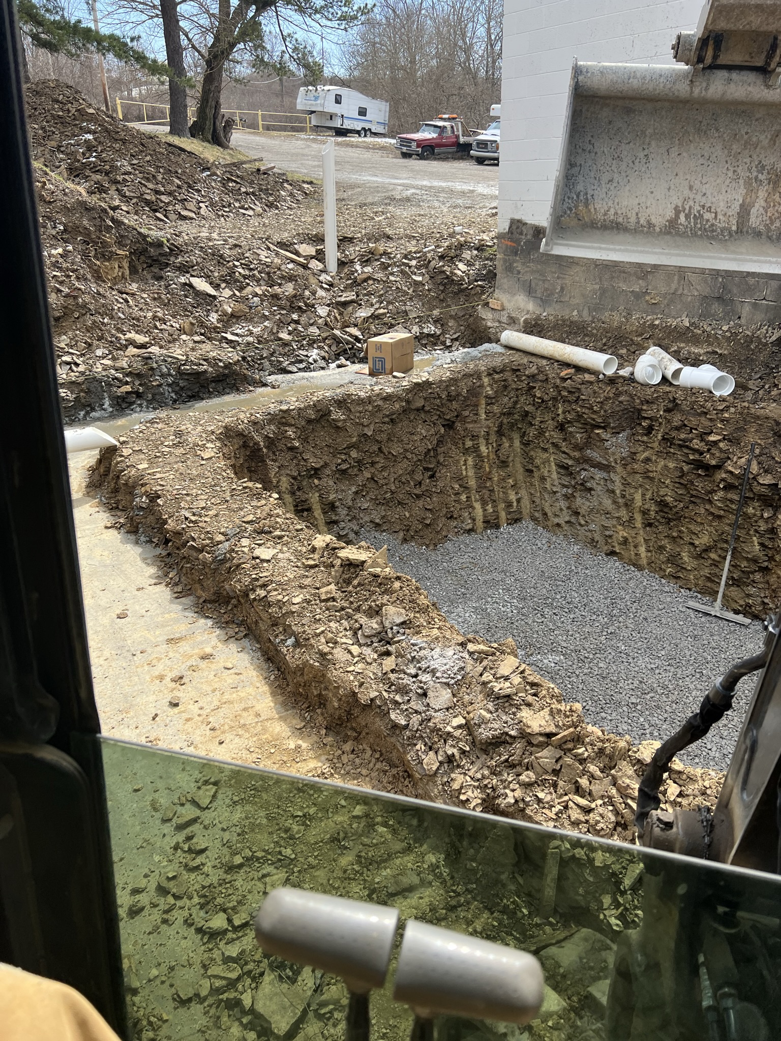 Aerial view from cab showing excavated foundation pit with gravel floor
