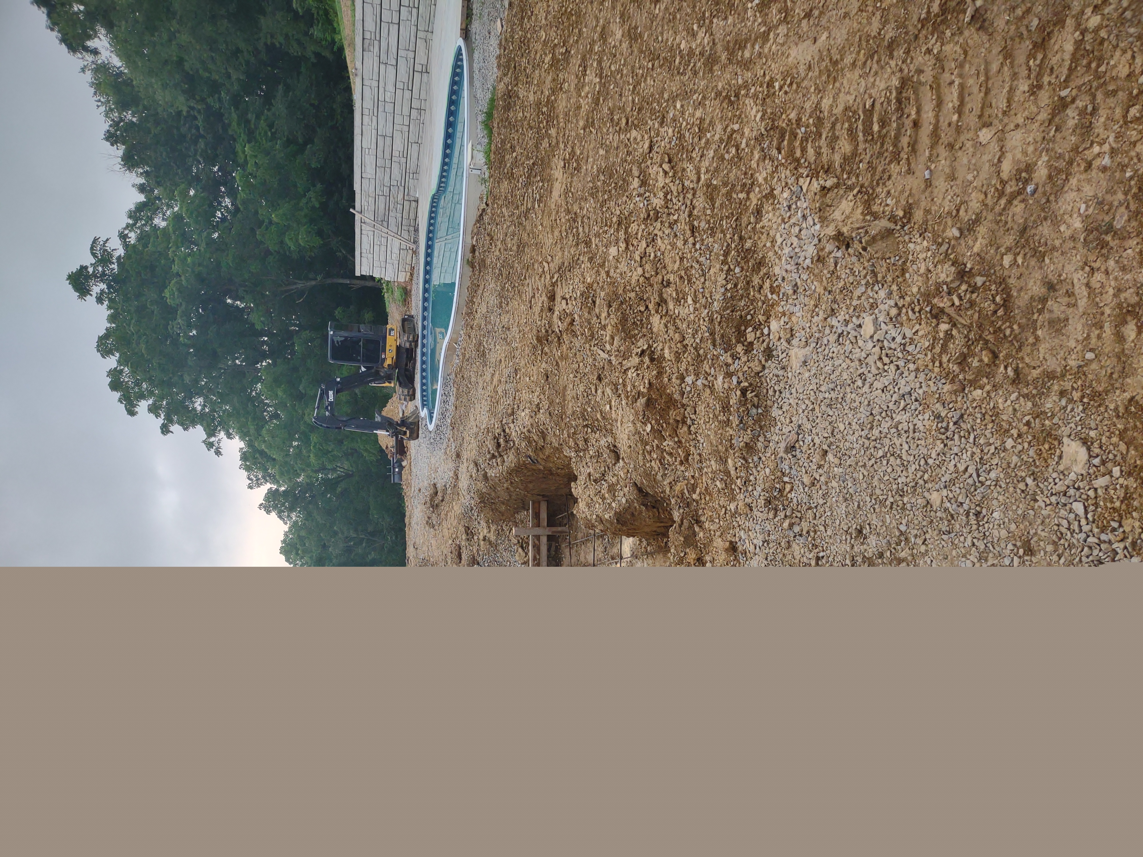 Early excavation phase with mini ex working around the pool