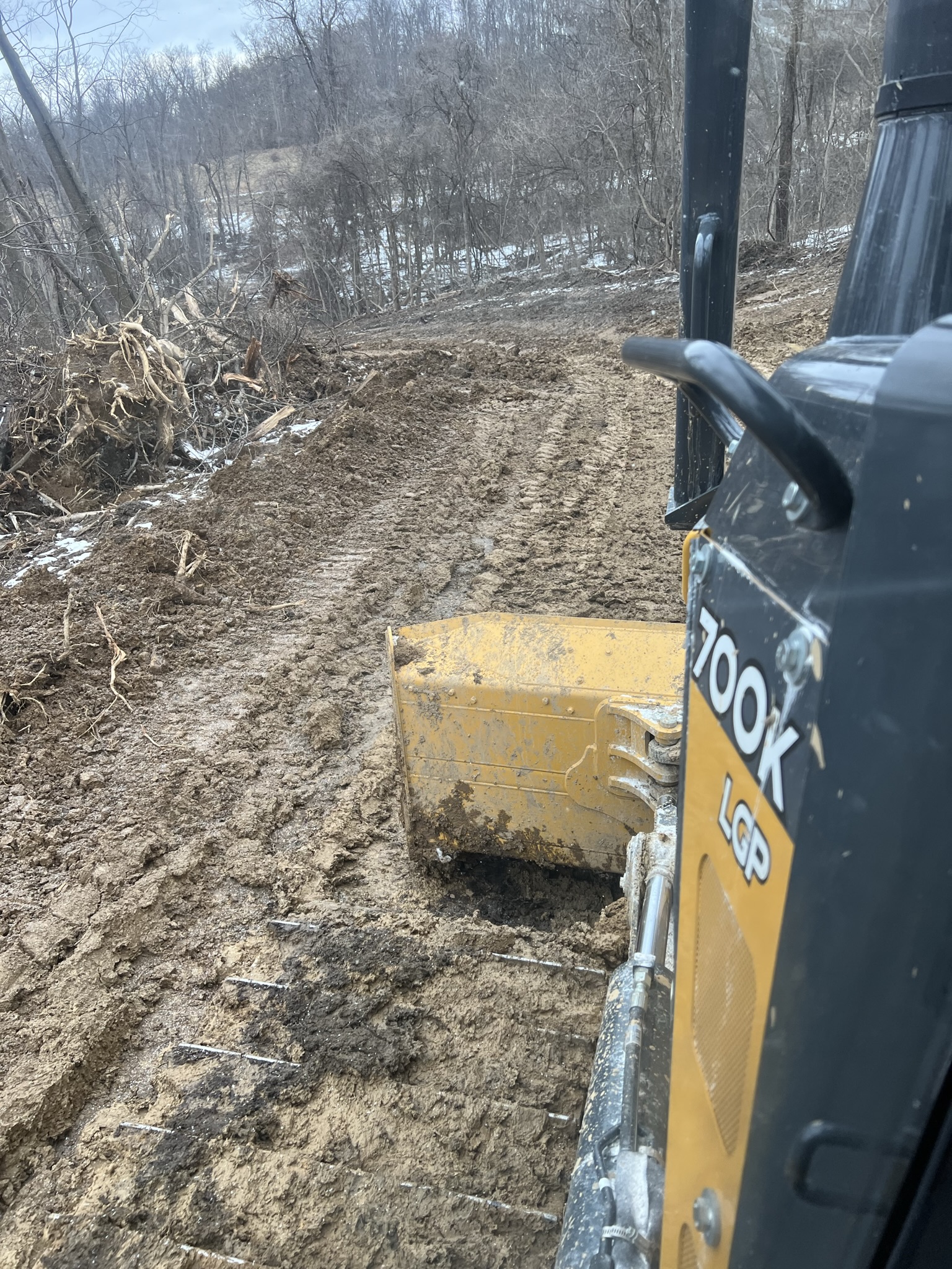 Wide hillside view with Komatsu dozer grading the pad