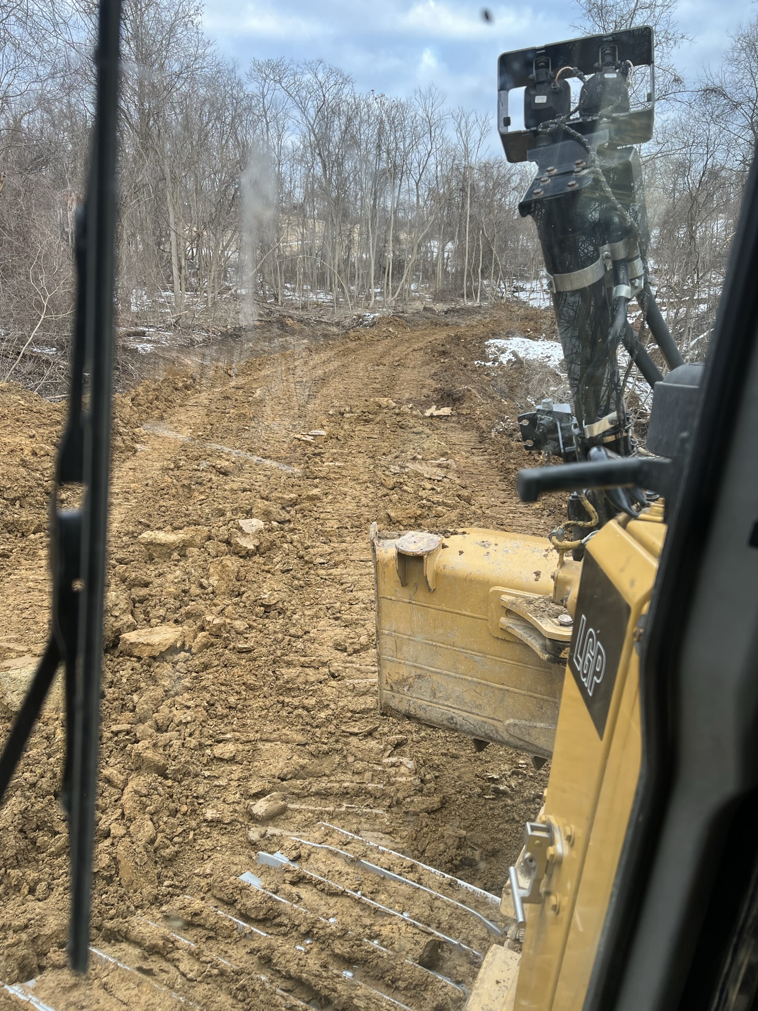Dozer pushing road bed with burn smoke visible