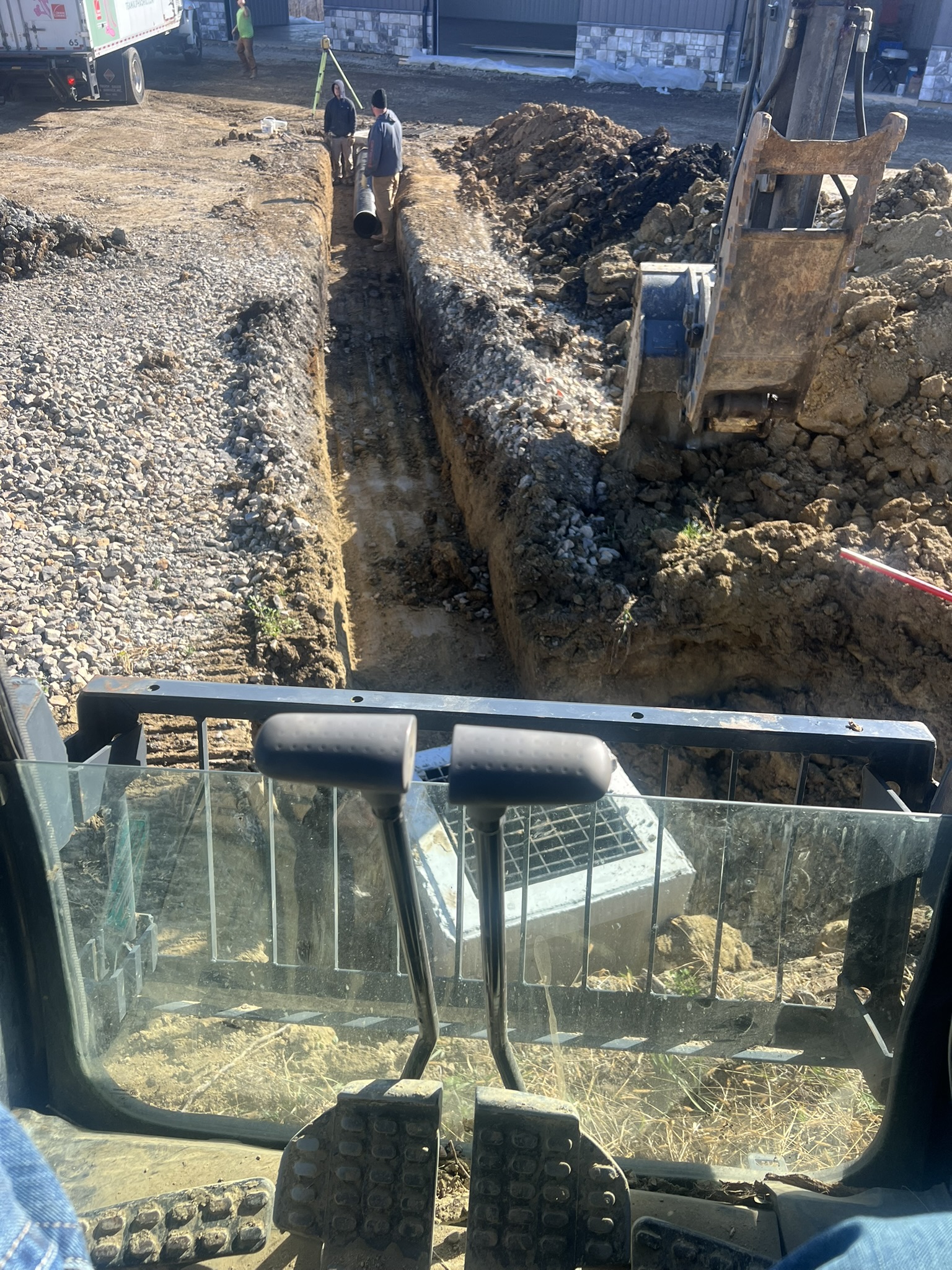 Pipe installation crew working long drainage trench