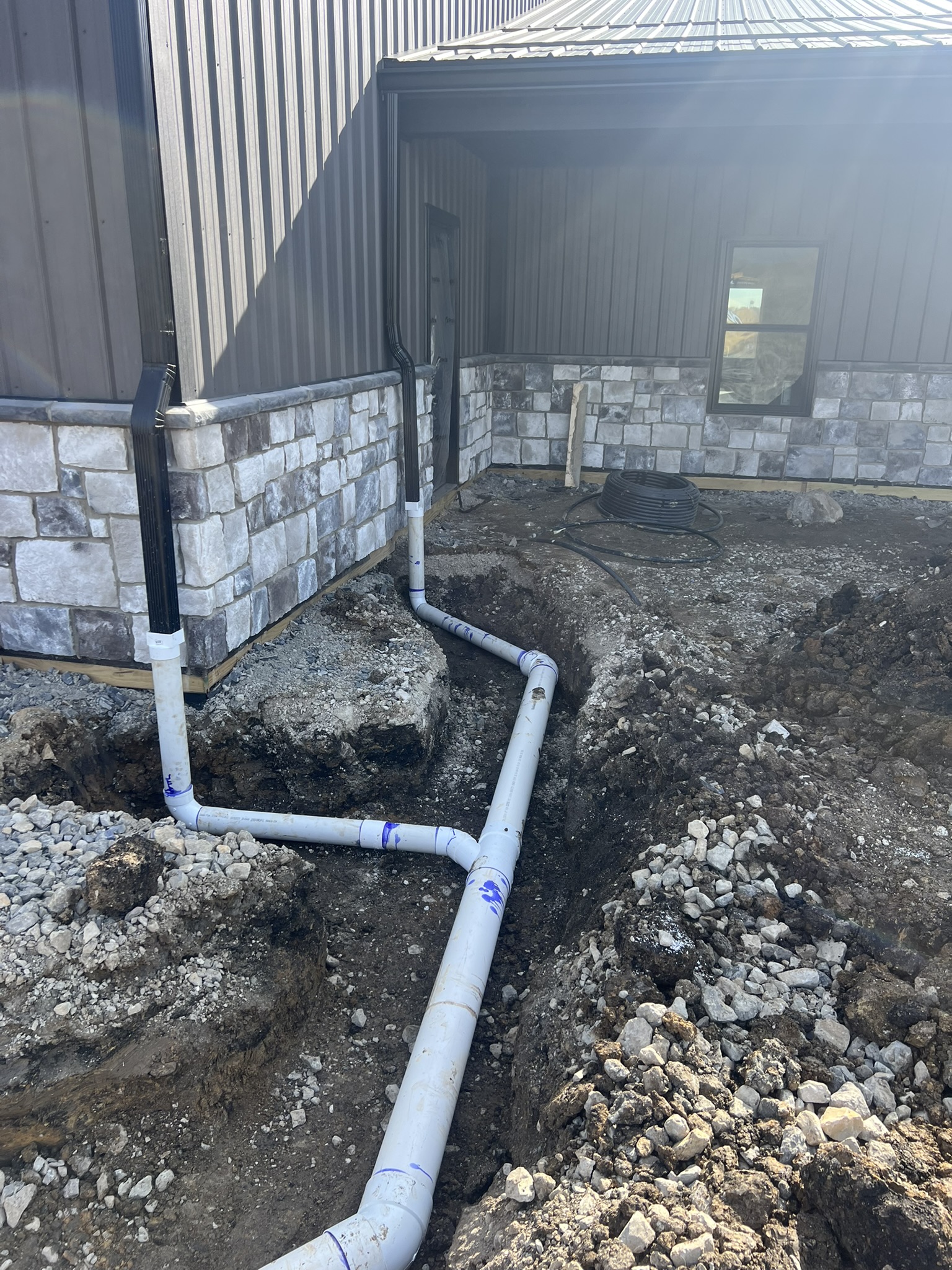 PVC drain pipe manifold at barn foundation