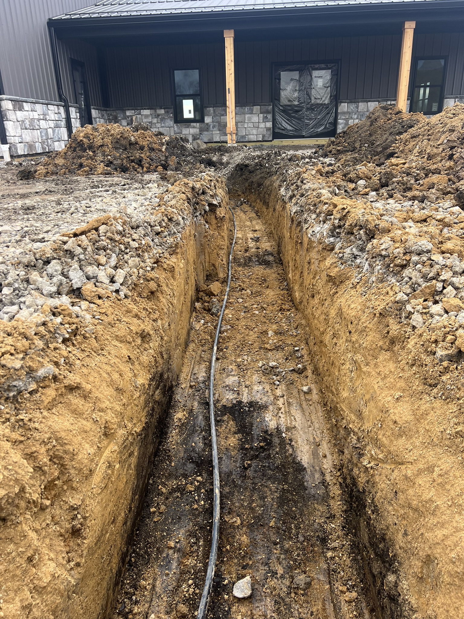 Electrical conduit trench cut toward barn