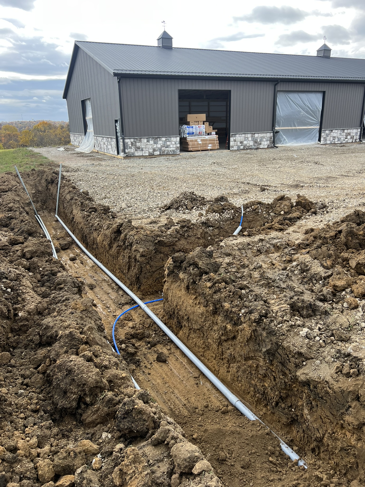 Utility trench approaching barn with water line in place